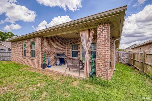 a view of a house with backyard porch and sitting area