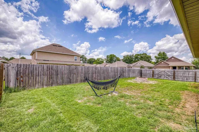 a backyard of a house with glass top table and chairs