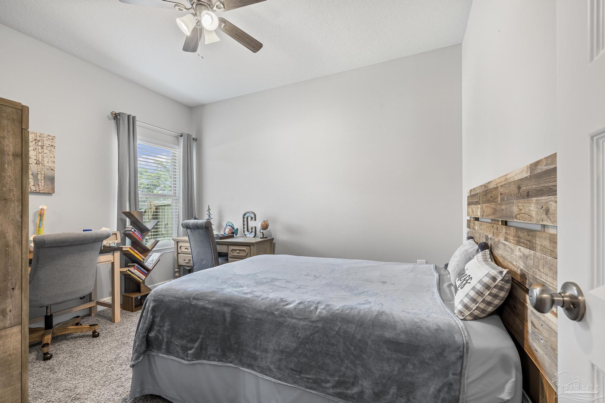 5375 Red Shoulder Road Pace, FL 32571 - Photo 6 of 40 a bedroom with a bed and a chandelier