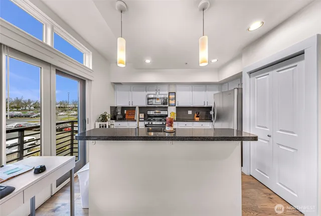 a kitchen with stainless steel appliances granite countertop a sink refrigerator and microwave