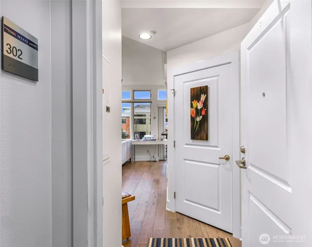 a view of a hallway with wooden floor and a cabinet