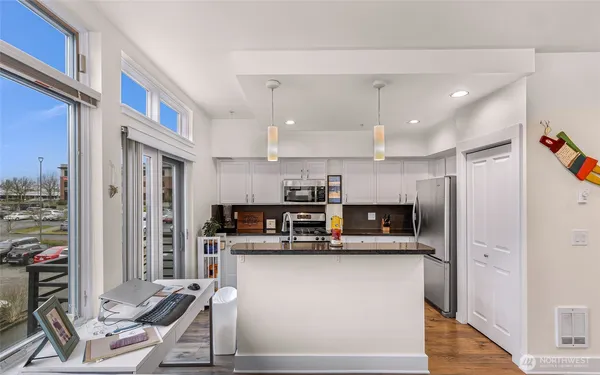 a kitchen with stainless steel appliances kitchen island granite countertop a refrigerator and cabinets