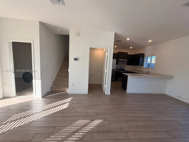 a view of kitchen with refrigerator and cabinets