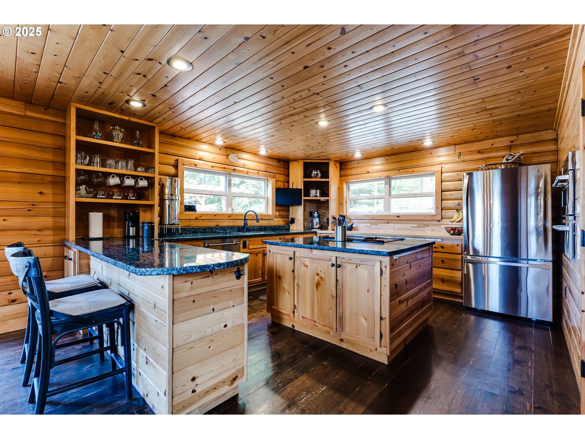 86561 R.R. Baker Road Springfield, OR 97478 - Photo 7 of 47 a kitchen with stainless steel appliances kitchen island granite countertop a table chairs and a wooden floor