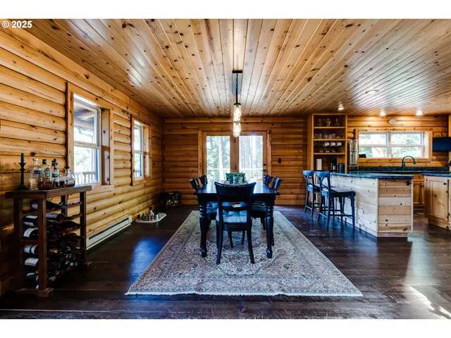 a kitchen with stainless steel appliances kitchen island granite countertop a table chairs and a wooden cabinets