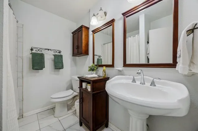 a bathroom with a toilet sink and mirror