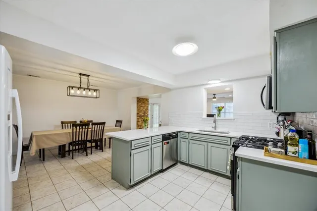a kitchen with a sink dining table and chairs