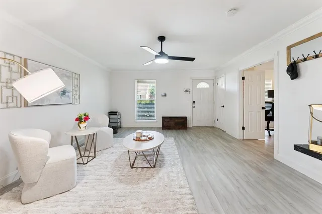 a living room with furniture and a wooden floor