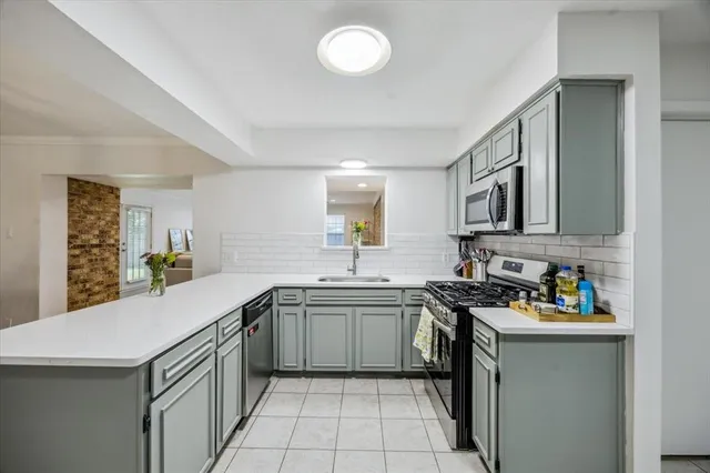 a kitchen with stainless steel appliances a sink stove and cabinets