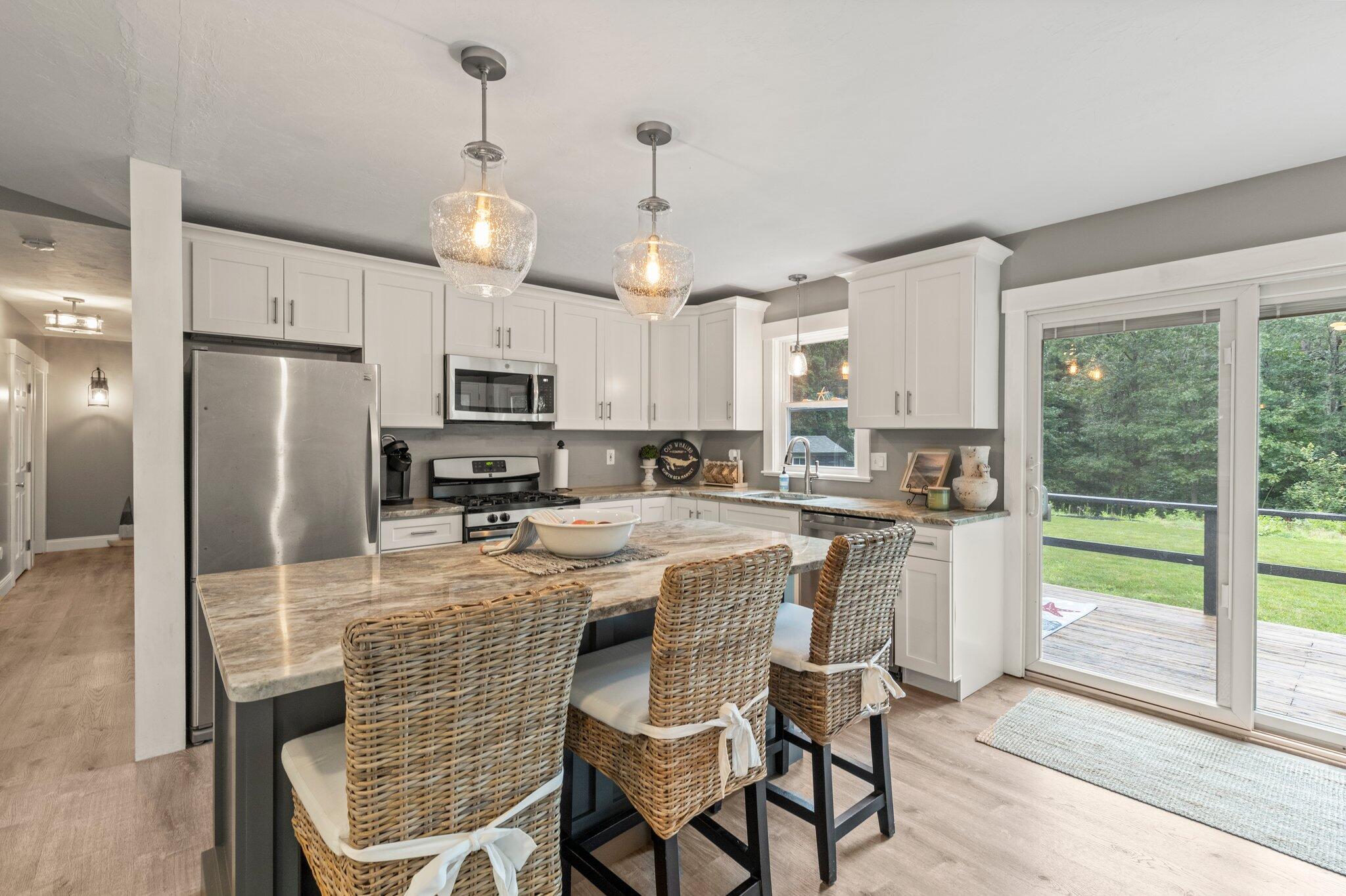 36 Chartwell Drive Buzzards Bay, MA 02532 - Photo 6 of 30 a kitchen with stainless steel appliances granite countertop a refrigerator a stove a sink dishwasher a dining table and chairs with wooden floor