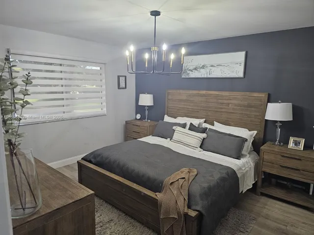 a bedroom with a bed and chandelier