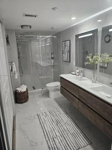 a bathroom with a double vanity sink toilet and shower