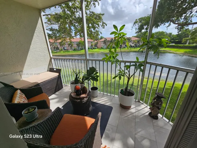 a view of a balcony with chairs and a potted plant