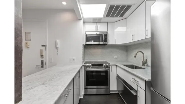 a open kitchen with a sink and refrigerator