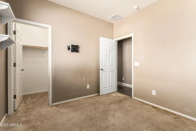 an empty room with closet and a bathroom