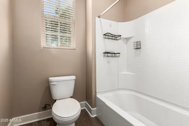 a white toilet sitting next to a bath tub
