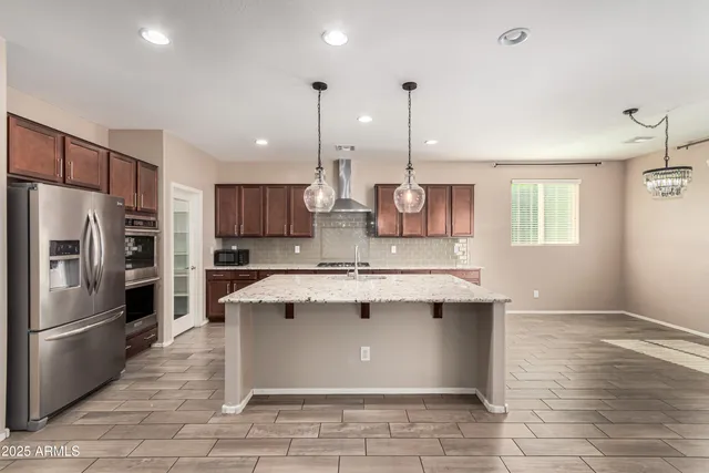 a kitchen with kitchen island a sink stainless steel appliances and cabinets