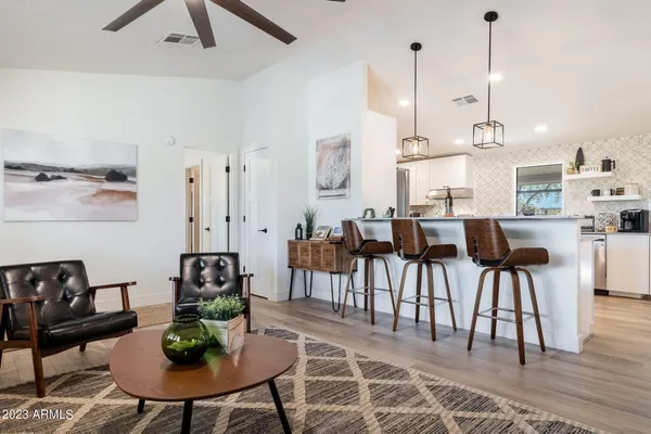 a kitchen with stainless steel appliances kitchen island a table chairs in it and white cabinets