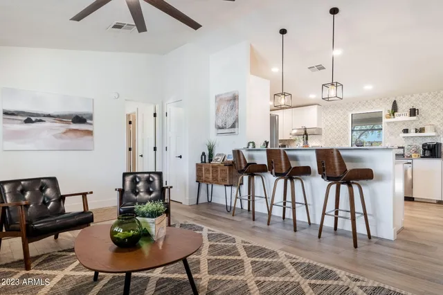 a kitchen with stainless steel appliances kitchen island a table chairs in it and white cabinets