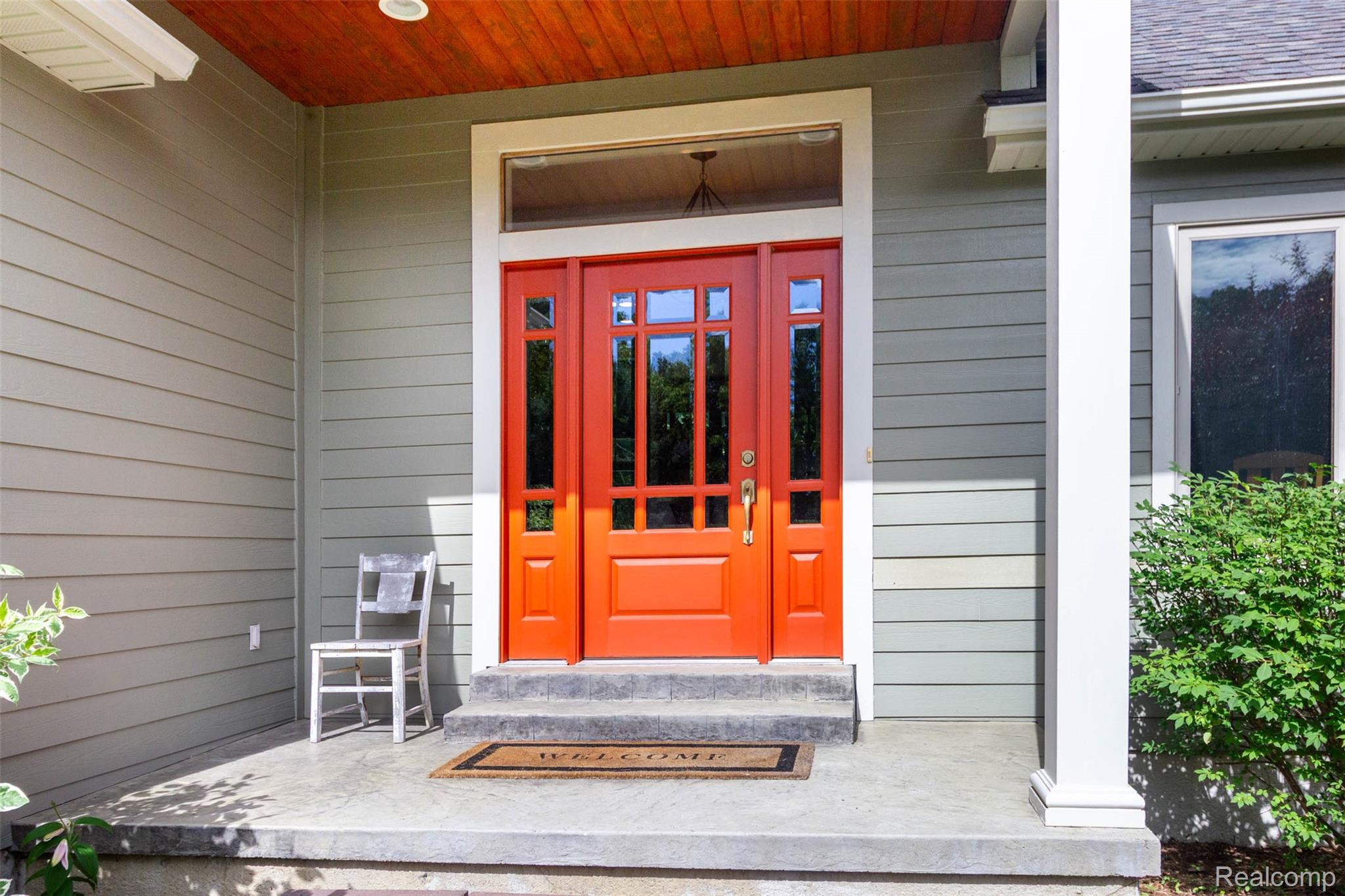 9887 Hadley Road Clarkston, MI 48348 - Photo 4 of 56 Vibrant red entry door with sidelights and transom window
