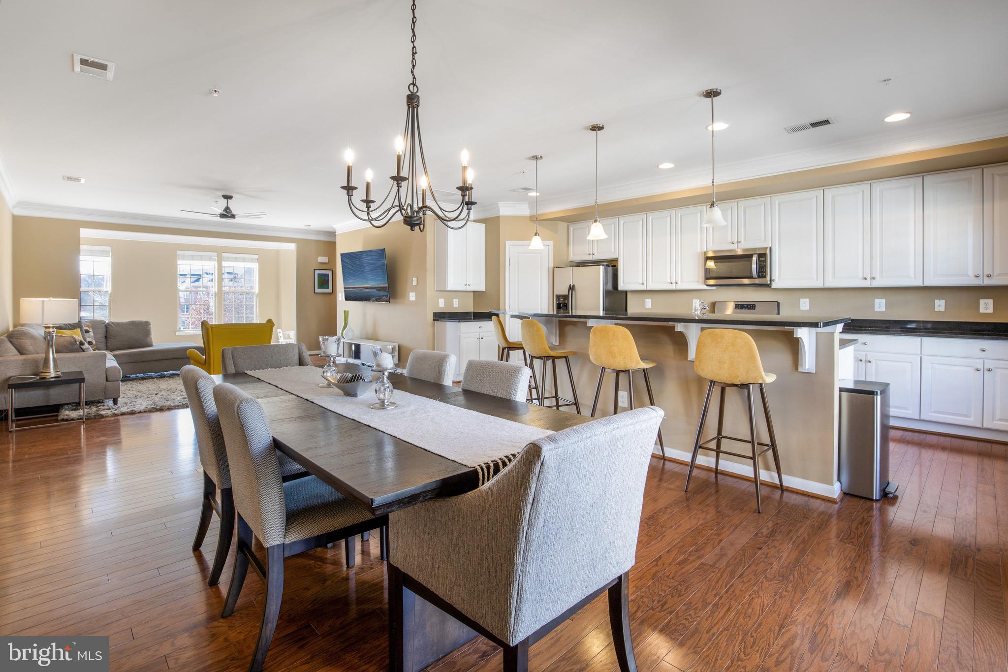 a dining room with stainless steel appliances kitchen island granite countertop a dining table chairs and view living room