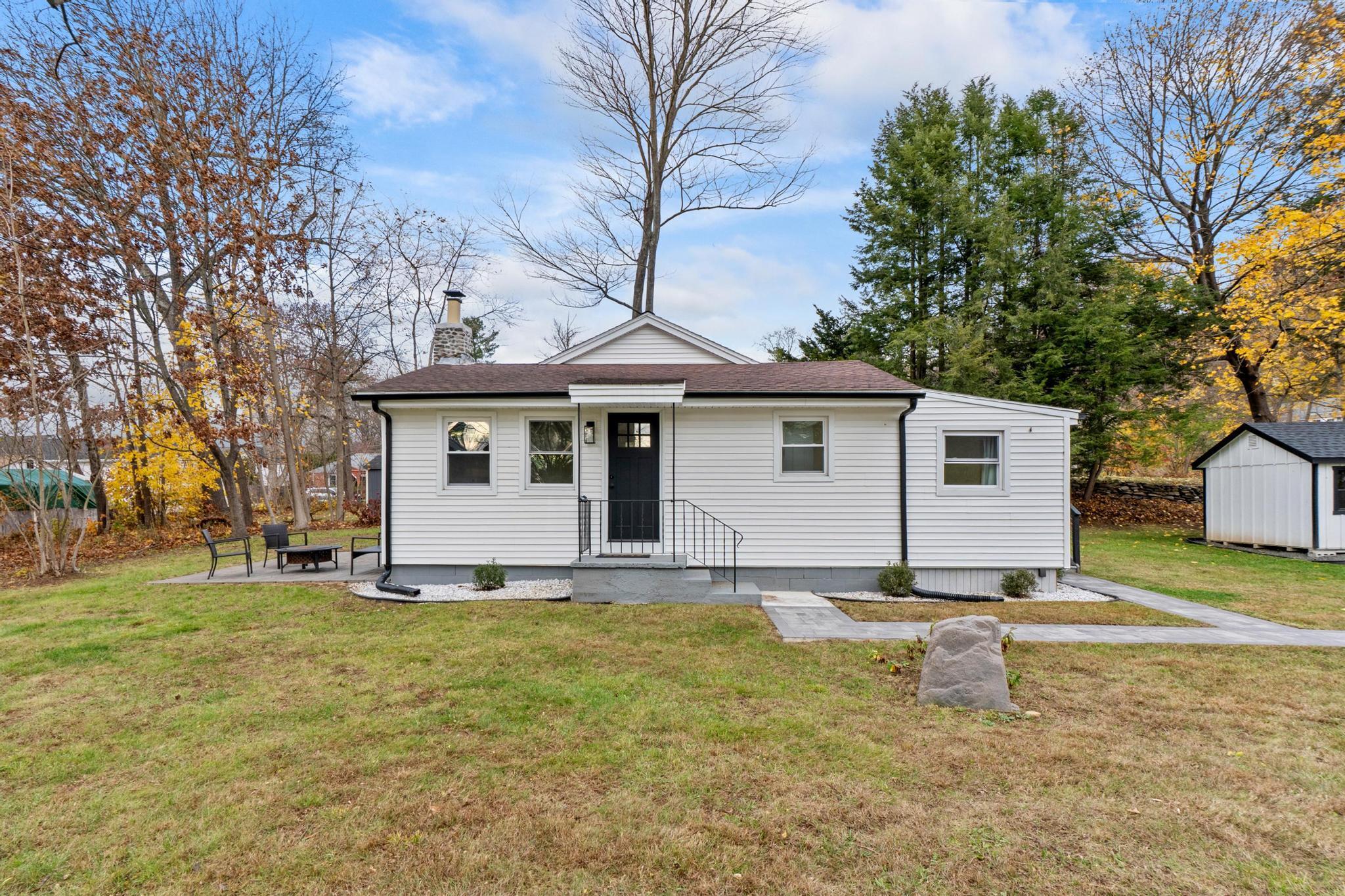 a view of a house with a yard and trees