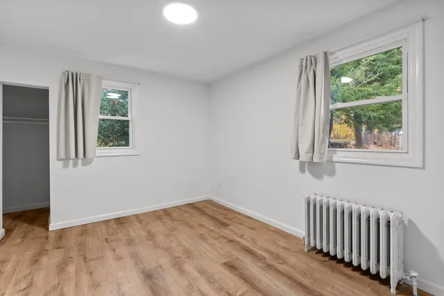 a view of empty room with wooden floor
