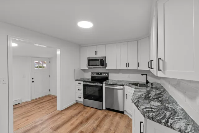 a kitchen with stainless steel appliances granite countertop a stove and a sink
