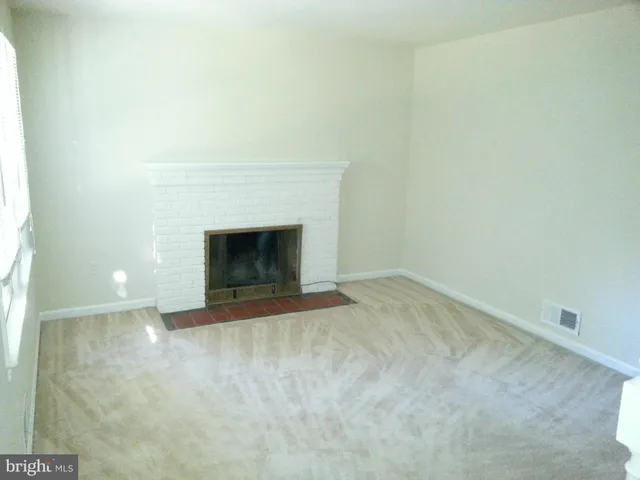 a view of empty room with a fireplace