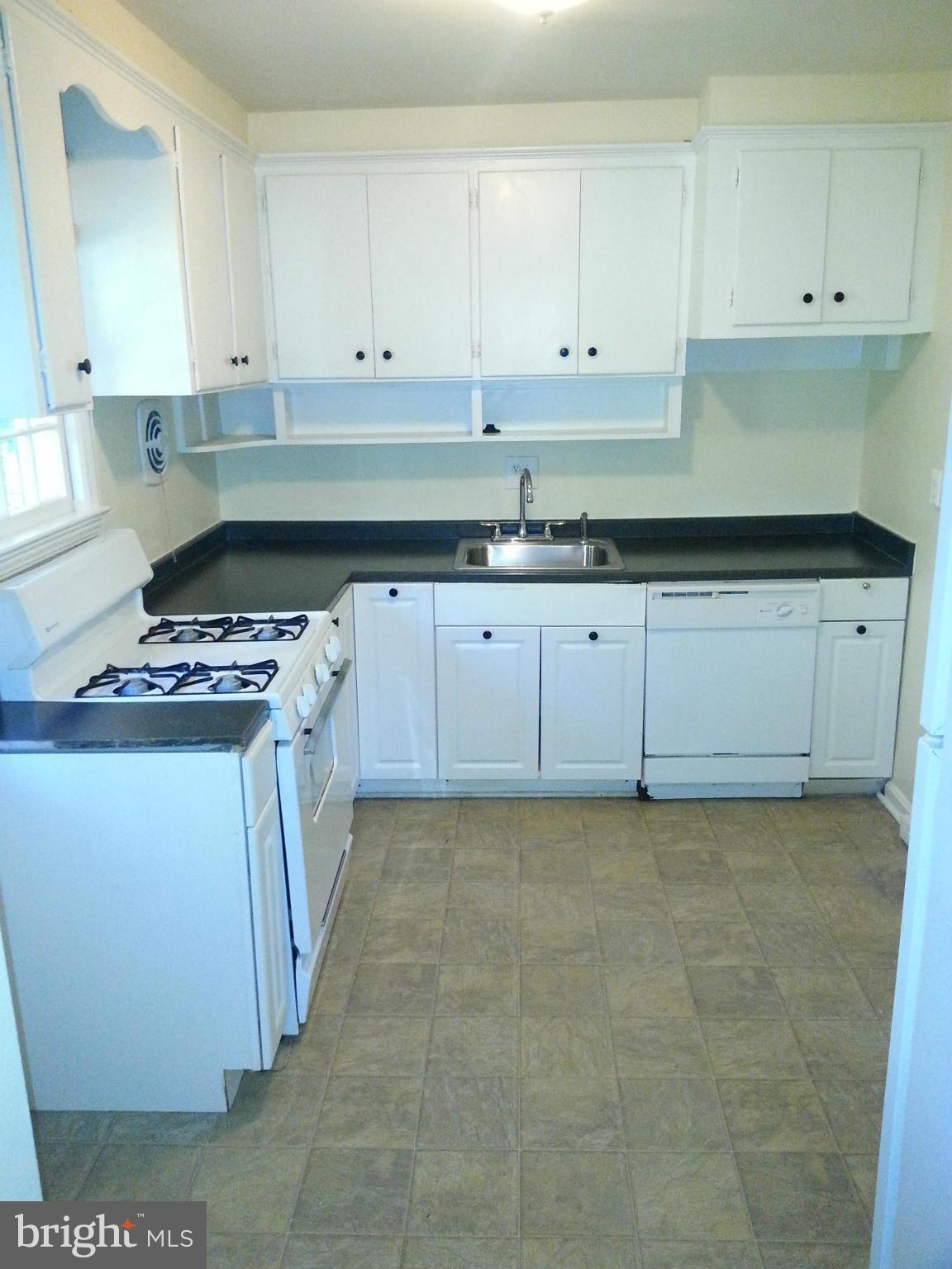 10001 Brunett Avenue Silver Spring, MD 20901 - Photo 7 of 23 a kitchen with granite countertop white cabinets and white appliances