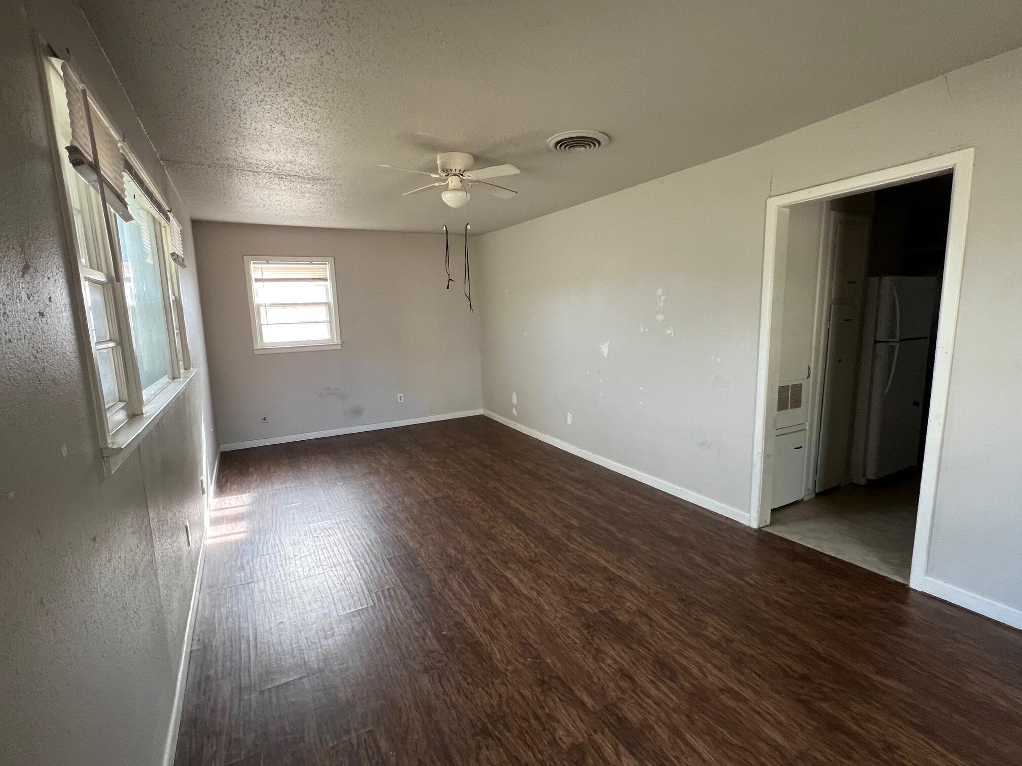 4403 31st Street, Unit B Lubbock, TX 79410 - Photo 2 of 7 an empty room with wooden floor and windows