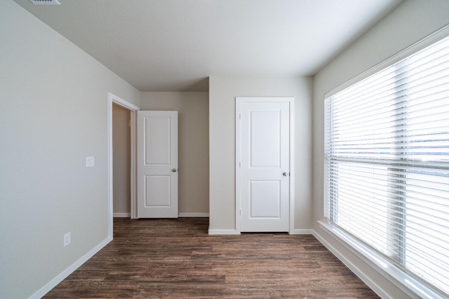 9706 Saratoga Avenue Lubbock, TX 79424 - Photo 11 of 11 a view of an empty room with wooden floor and a window