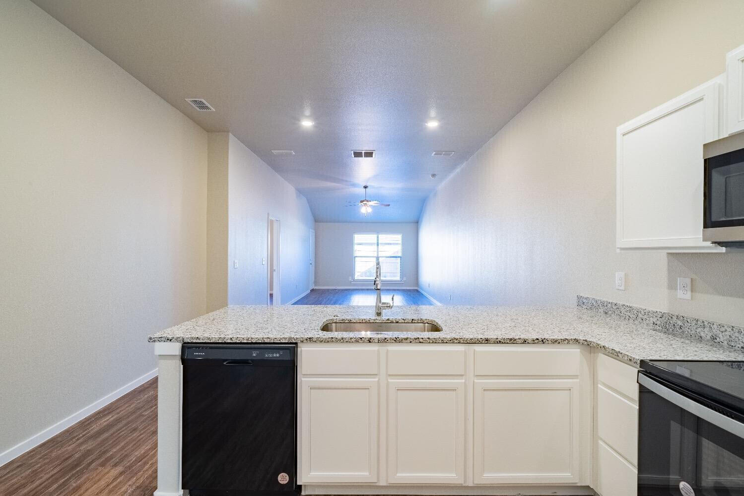 9706 Saratoga Avenue Lubbock, TX 79424 - Photo 3 of 11 a kitchen with kitchen island granite countertop counter top space a sink and cabinets