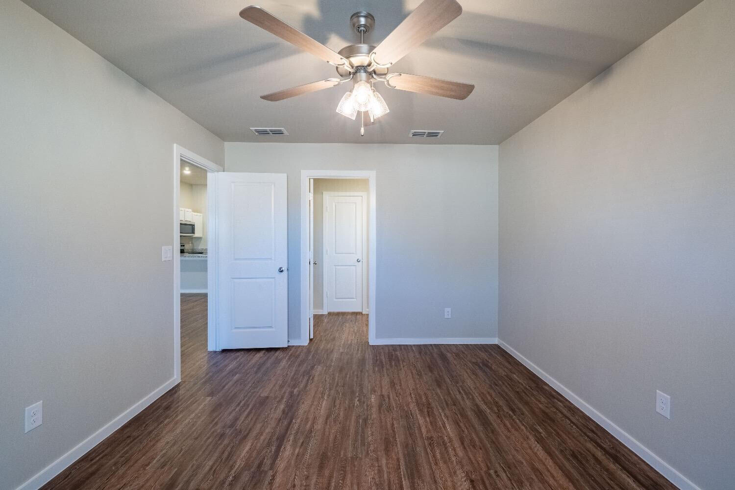 9706 Saratoga Avenue Lubbock, TX 79424 - Photo 5 of 11 wooden floor in an empty room with a window