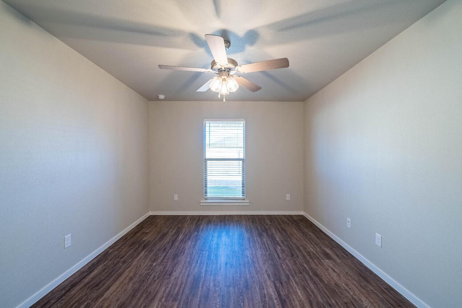 9706 Saratoga Avenue Lubbock, TX 79424 - Photo 8 of 11 wooden floor in an empty room with a window