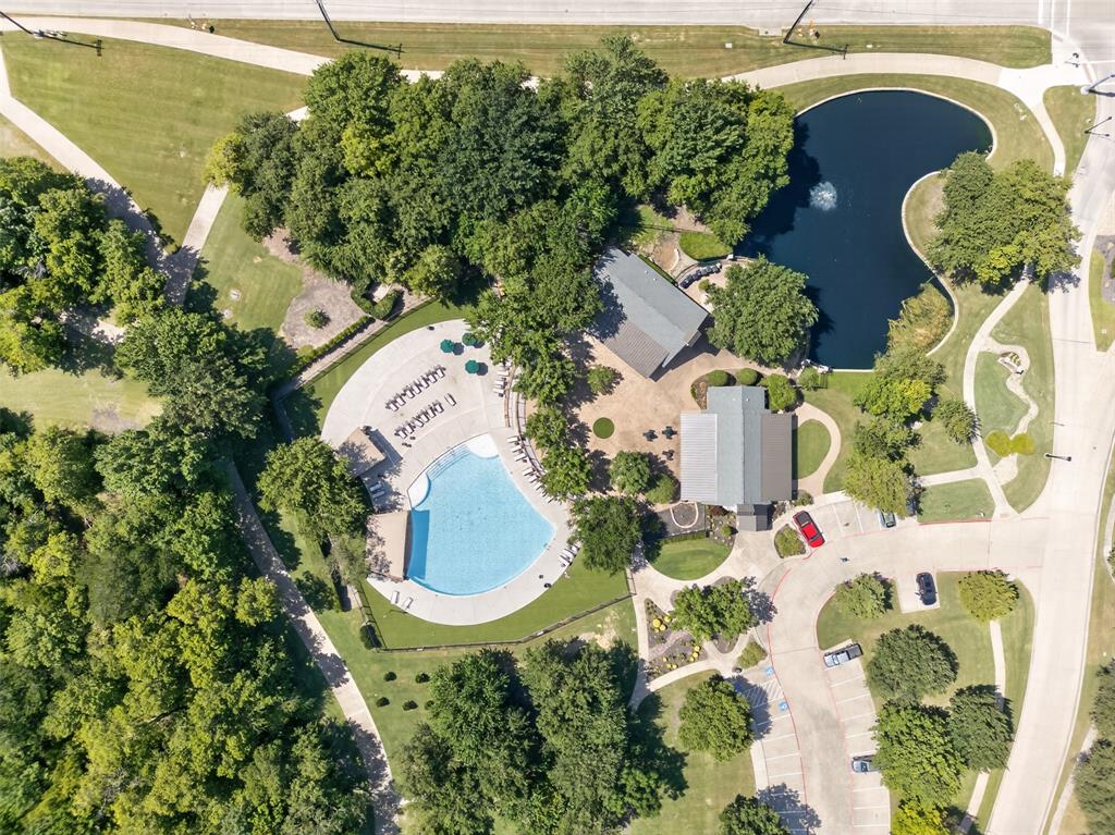 842 Sun Meadow Road Allen, TX 75013 - Photo 34 of 39 Expansive community recreation area featuring a large swimming pool, surrounding patio with lounge seating, two buildings with gabled roofs, and a pond with a water feature