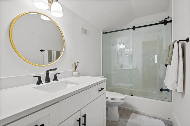 a view of a patio with table and chairs under an umbrella with a lake view