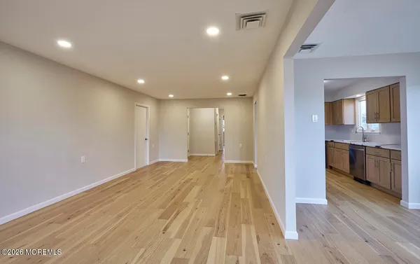 a view of a kitchen with a sink and wooden floor