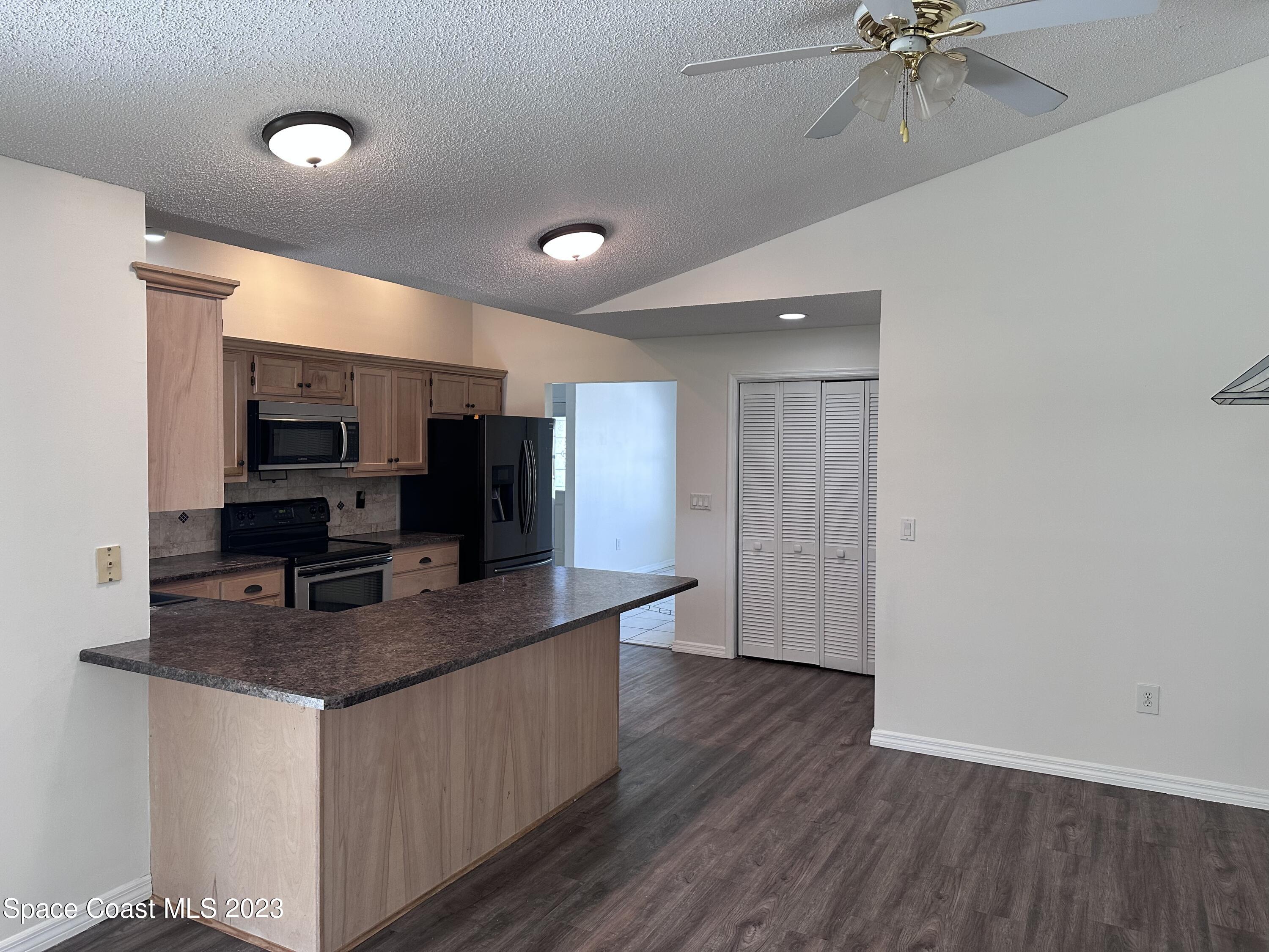 1369 Elcon Drive Melbourne, FL 32904 - Photo 6 of 13 a kitchen with stainless steel appliances granite countertop a sink microwave and cabinets