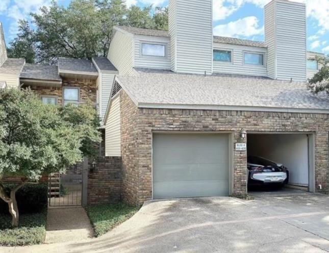 7340 Skillman Street, Unit 405 Dallas, TX 75231 - Photo 13 of 18 Multi-level townhome featuring brick and horizontal siding exteriors, a two-car garage, and multiple windows across the upper levels