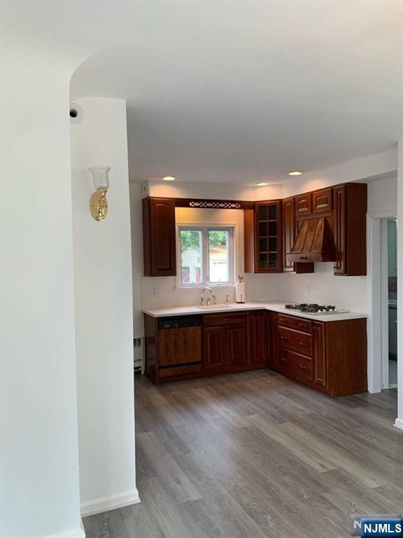 73 East Gouverneur Avenue Rutherford, NJ 07070 - Photo 6 of 33 a kitchen with stainless steel appliances kitchen island granite countertop a stove a refrigerator a sink a dining table and chairs with wooden floor