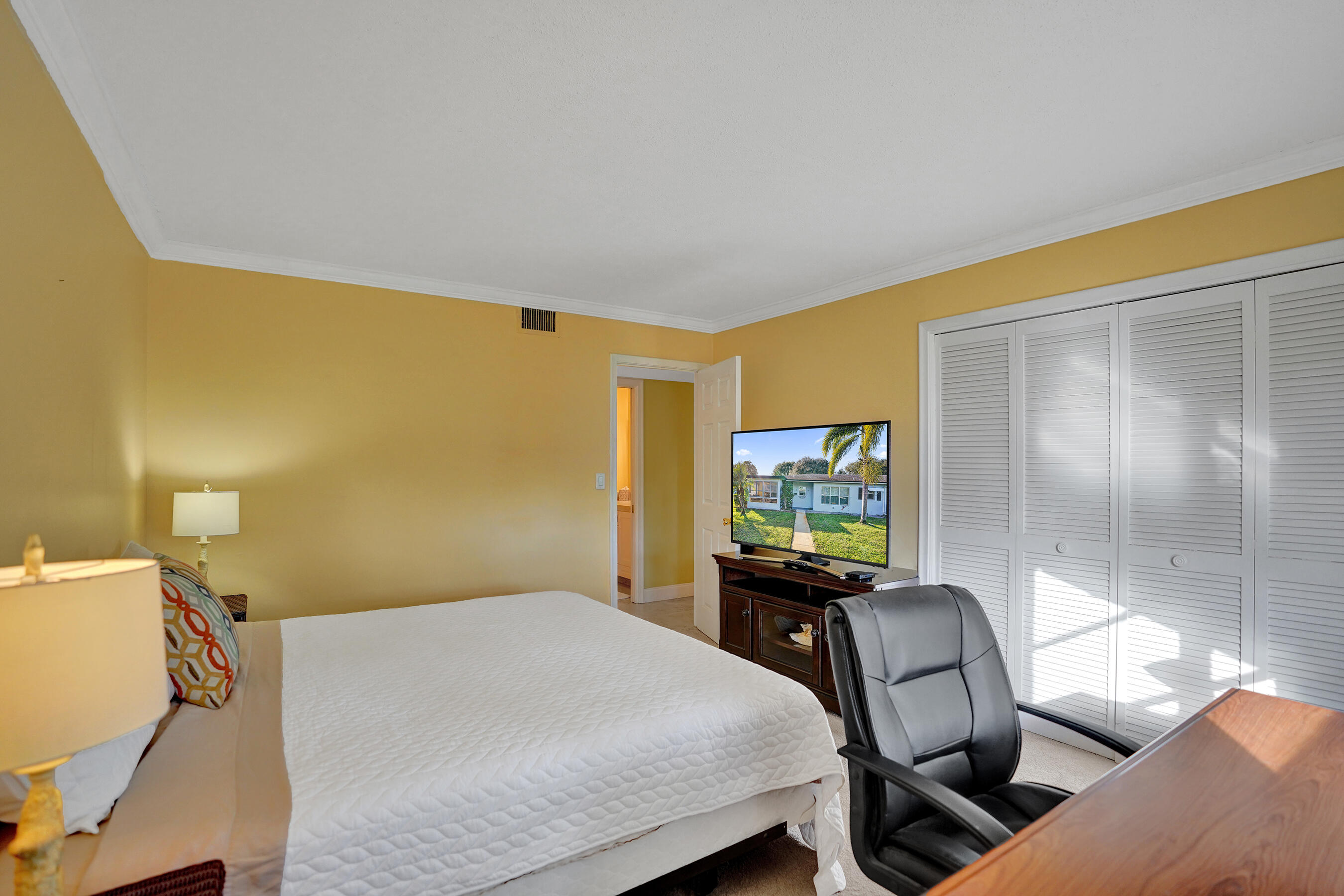 515 High Point Drive, Unit A Delray Beach, FL 33445 - Photo 26 of 60 a bedroom with a bed and wooden floor