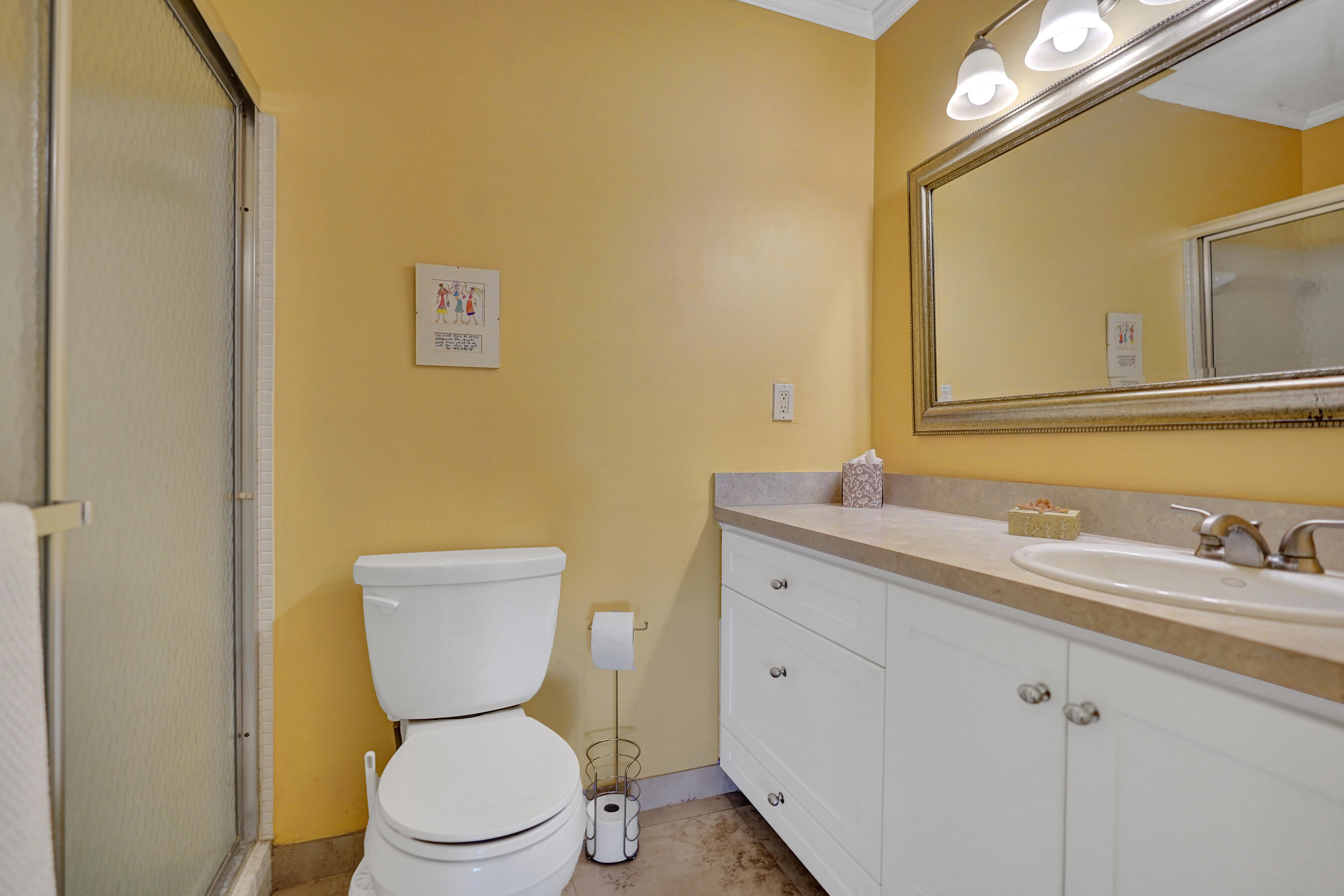 515 High Point Drive, Unit A Delray Beach, FL 33445 - Photo 27 of 60 a bathroom with a toilet sink and mirror