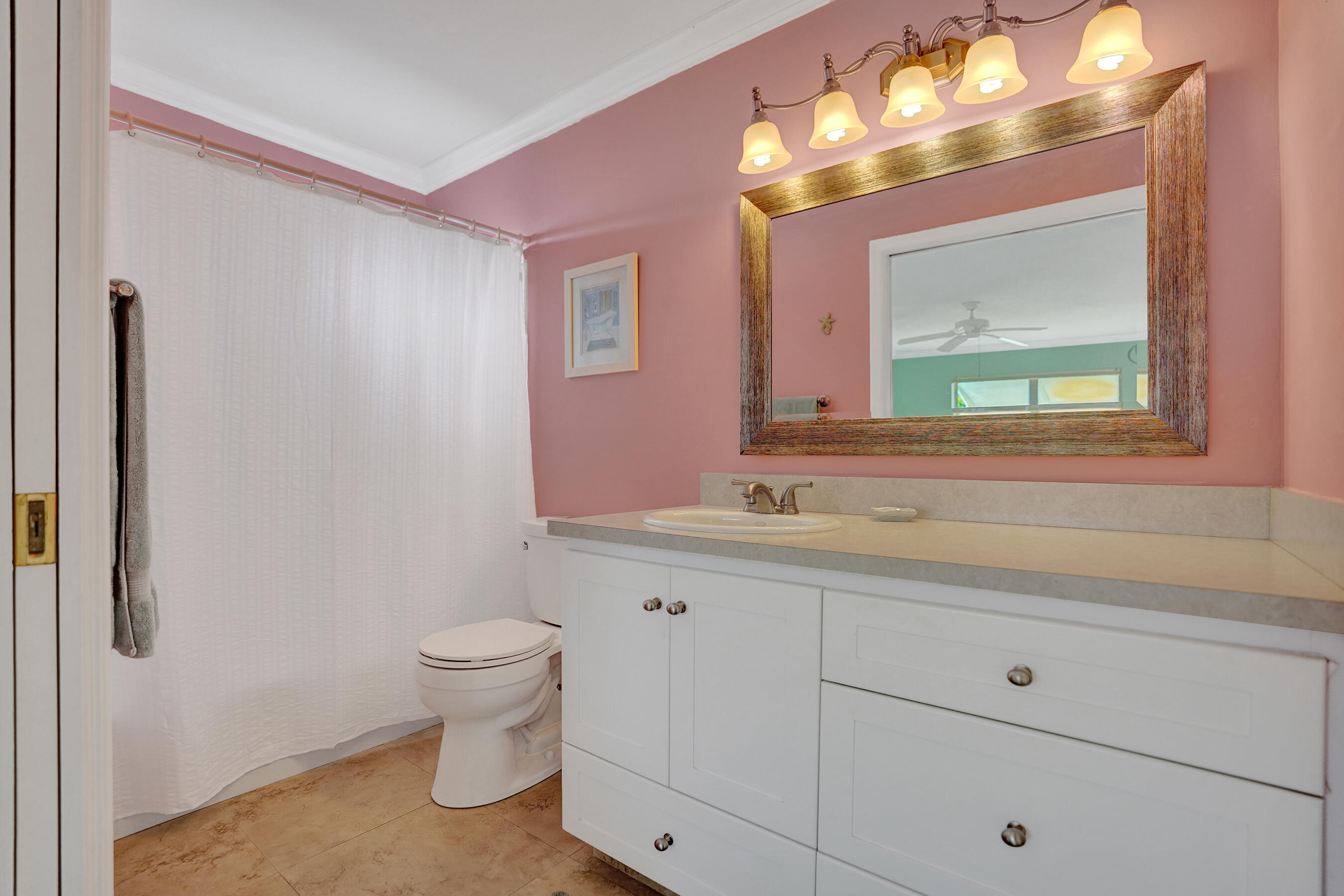 515 High Point Drive, Unit A Delray Beach, FL 33445 - Photo 36 of 60 a bathroom with a toilet sink and mirror