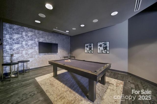 a living room with a flat screen tv and kitchen view