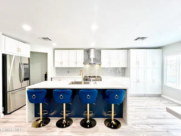 a kitchen with stainless steel appliances a sink and a refrigerator