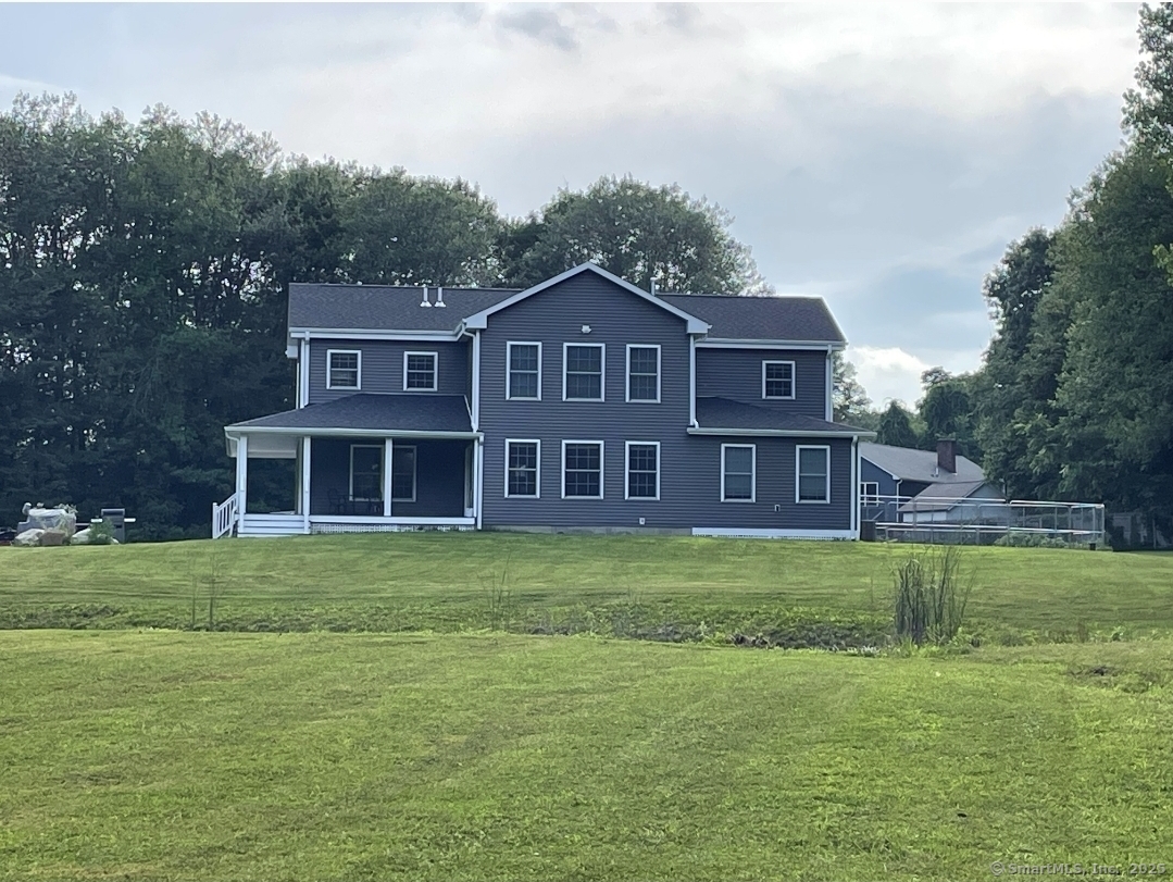 a view of a big house with a big yard and large trees