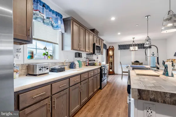 a kitchen with stainless steel appliances granite countertop sink stove top oven and cabinets