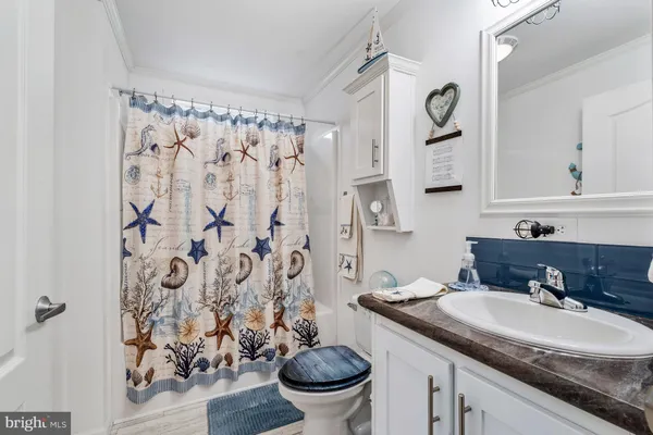 a bathroom with a granite countertop sink and a toilet
