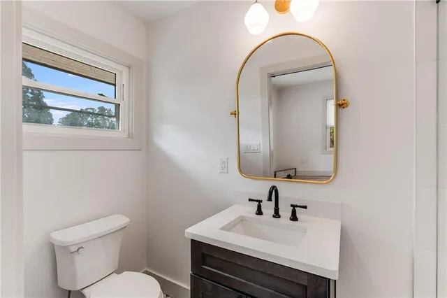 a bathroom with a toilet sink and mirror